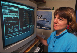 Bower uses a closed-circuit television to enlarge text to readable size. (Photo by Tom Kleindinst, Woods Hole Oceanographic Institution)
